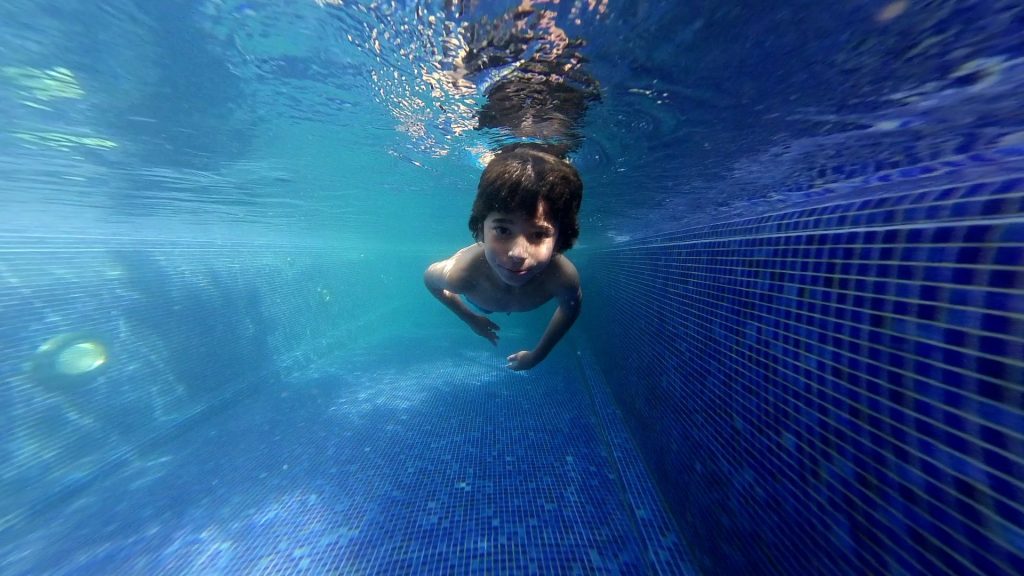Poolreinigung Kmobateva Junge unter Wasser