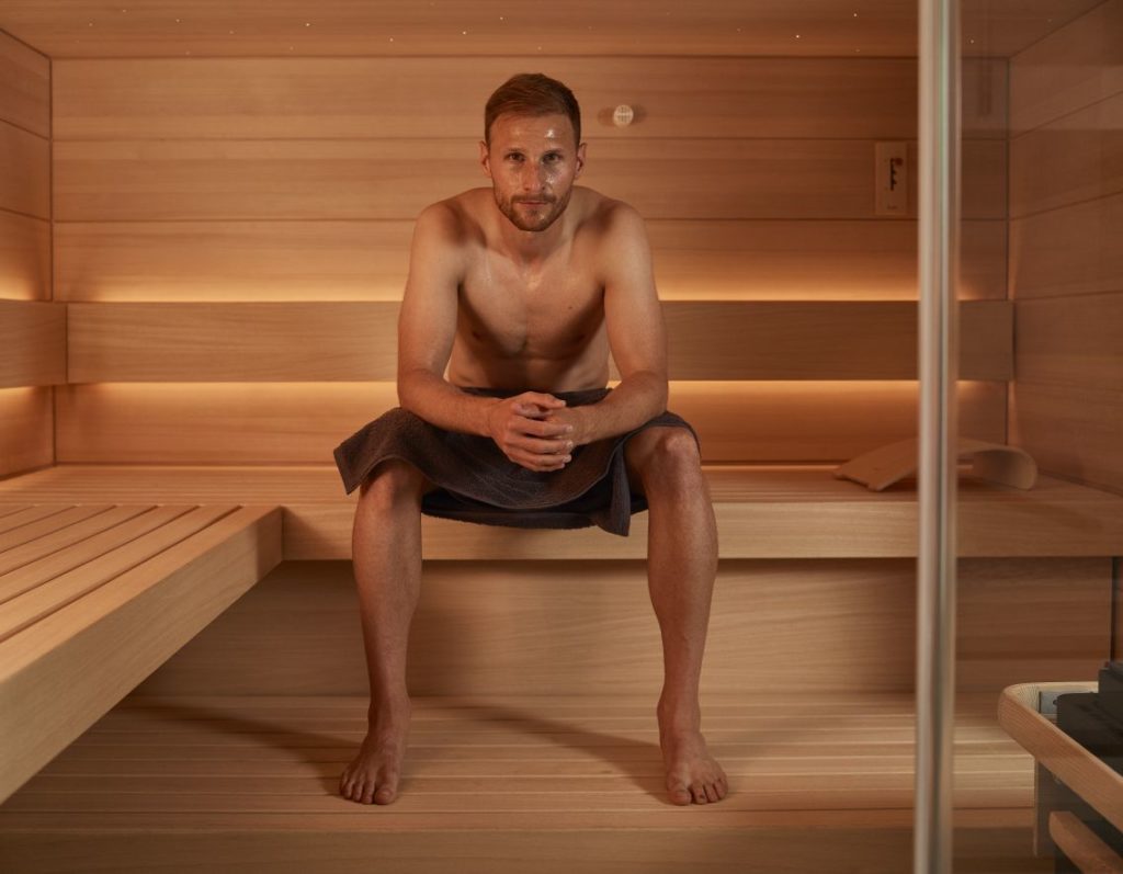Sauna: Wärme, die uns gut tut - Benedikt Howedes sitzt auf einer Bank und posiert vor der Kamera - Sauna