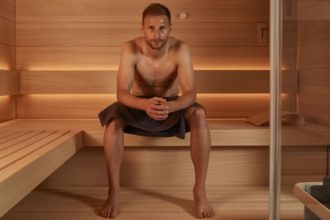 Sauna: Wärme, die uns gut tut - Benedikt Howedes sitzt auf einer Bank und posiert vor der Kamera - Sauna