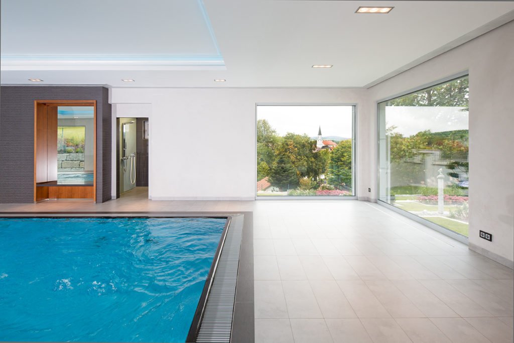 Ein Hallenbad mitten im Idyll - Ein Raum mit einem Pool vor einem Fenster - Die Architektur