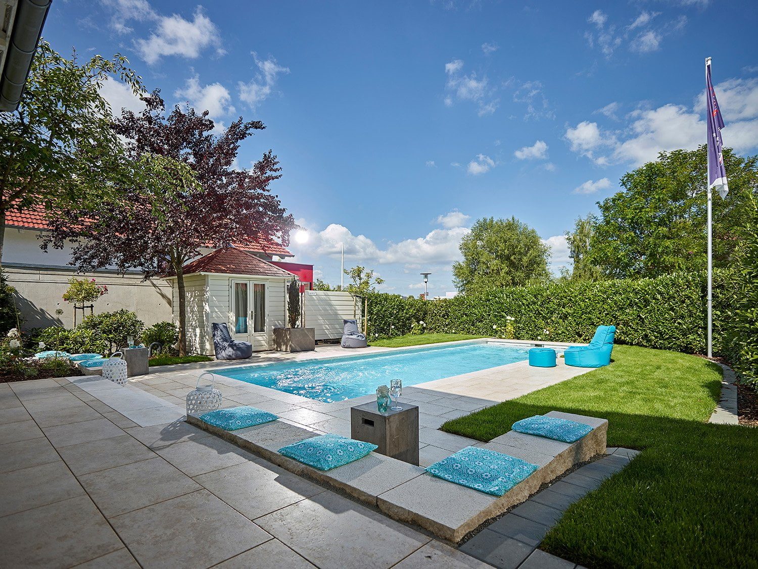 Elegant wurde dieser Pool in den großen Garten integriert. Die Beckenumrandung aus Kanfanar Naturstein lädt zum Sonnenbaden ein. Foto: Tom Philippi