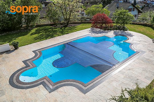 Ein Pool mit einer halb geschlossenen Rollladenabdeckung