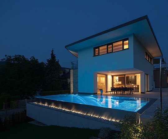 Mit nur einem Fingertip setzen Sie den Pool in Szene! Ein beleuchteter Pool mit Überlaufrinne und Nackenschwalldusche.