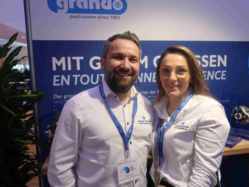 Mann und frau in weißen Hemden am Stand von Grando.