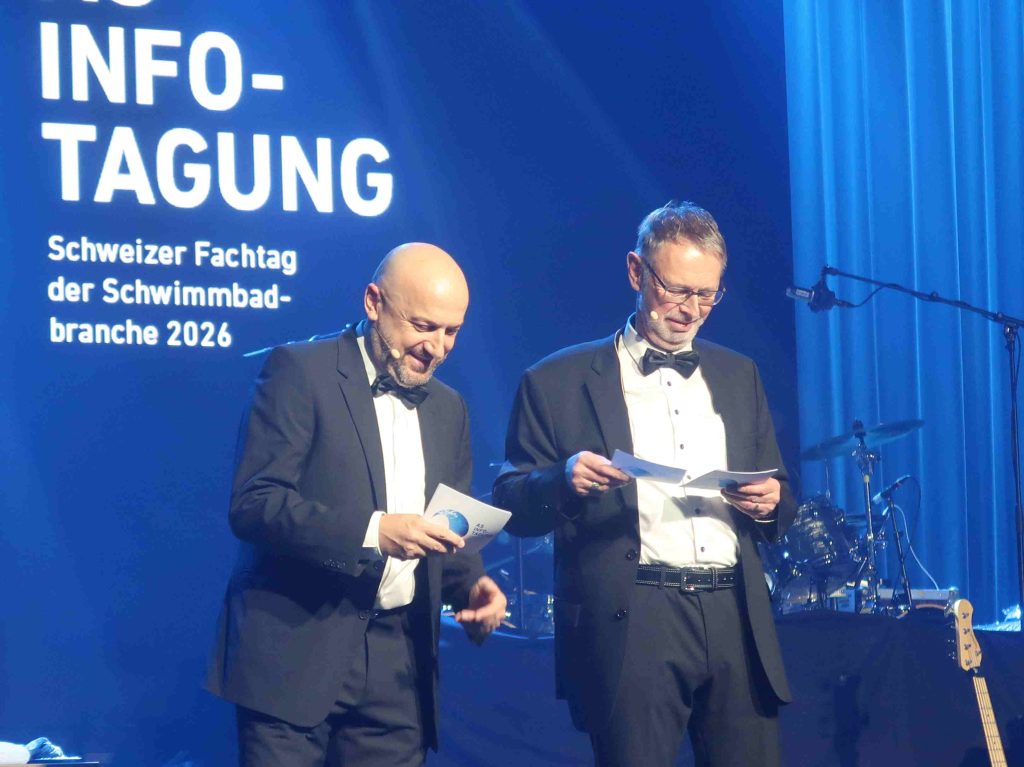 Die beiden Geschäftsführer Domenico Conte und Yves Burgener im schwarzen Anzug mit Fliege auf der Bühne bei der As Infotagung.