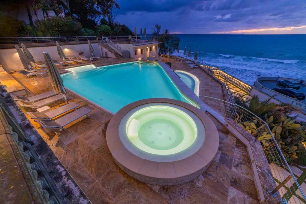 Ein stimmungsvoll beleuchteter Pool und Whirpool in der Abenddämmerung.